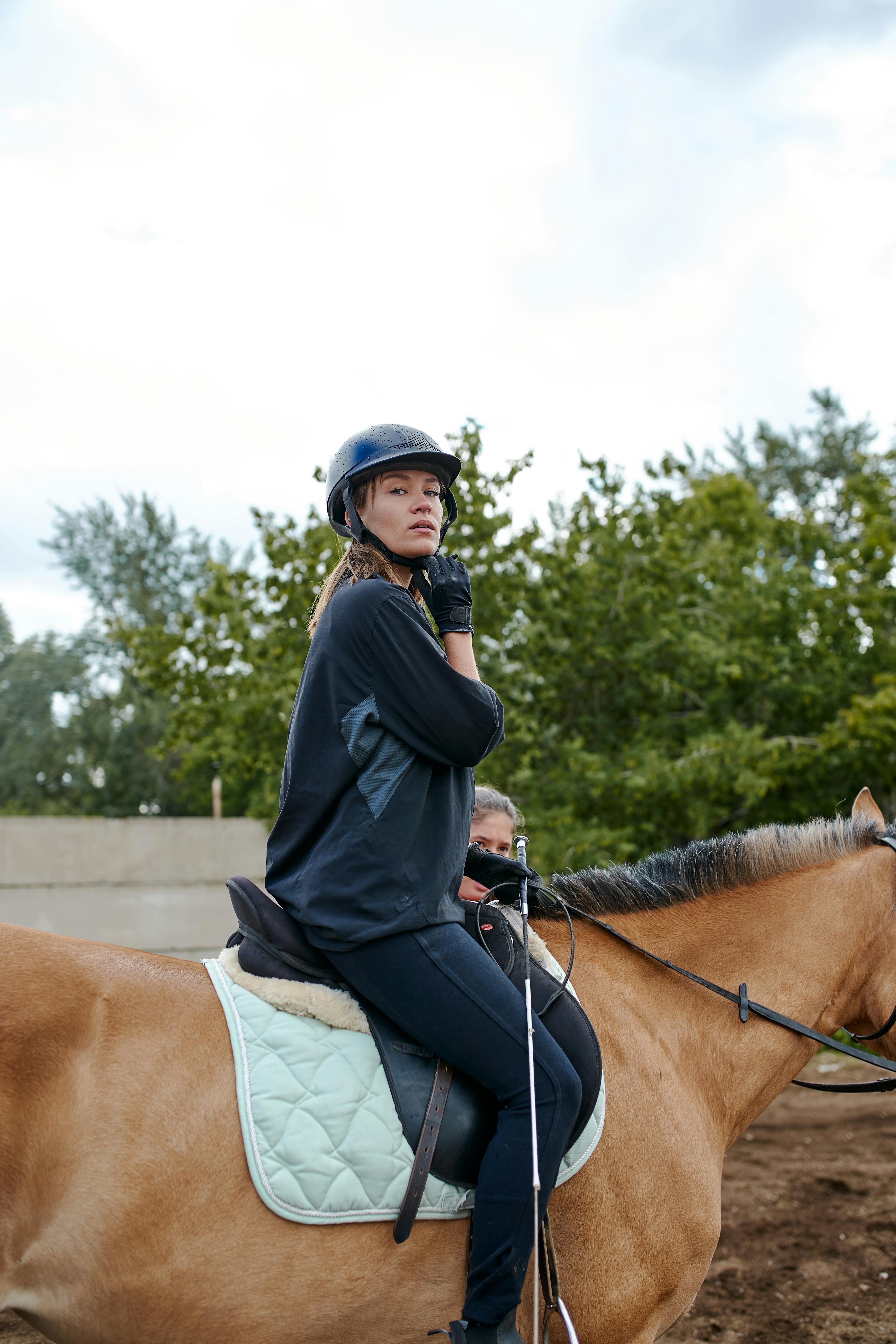 confident horsewoman riding horse in countryside