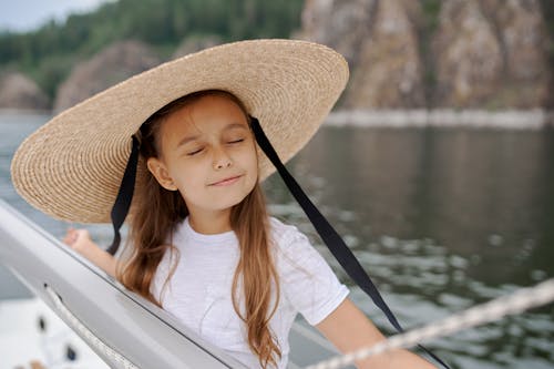 帽子的小女孩在遊艇