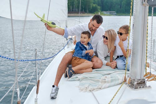 Счастливая семья на парусной лодке в море