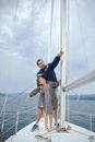 Man with daughter on sailboat in sea