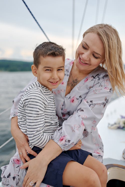 擁抱兒子的愉快的婦女在遊艇