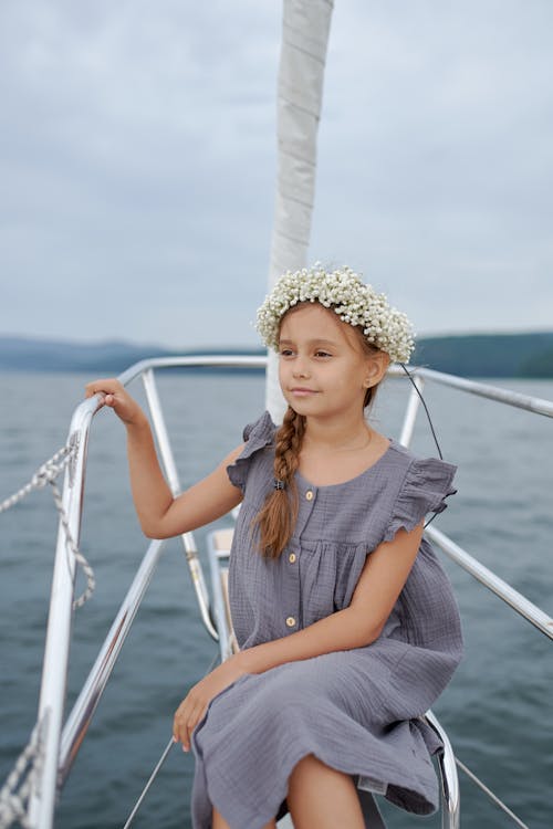 Stylish little girl resting on yacht