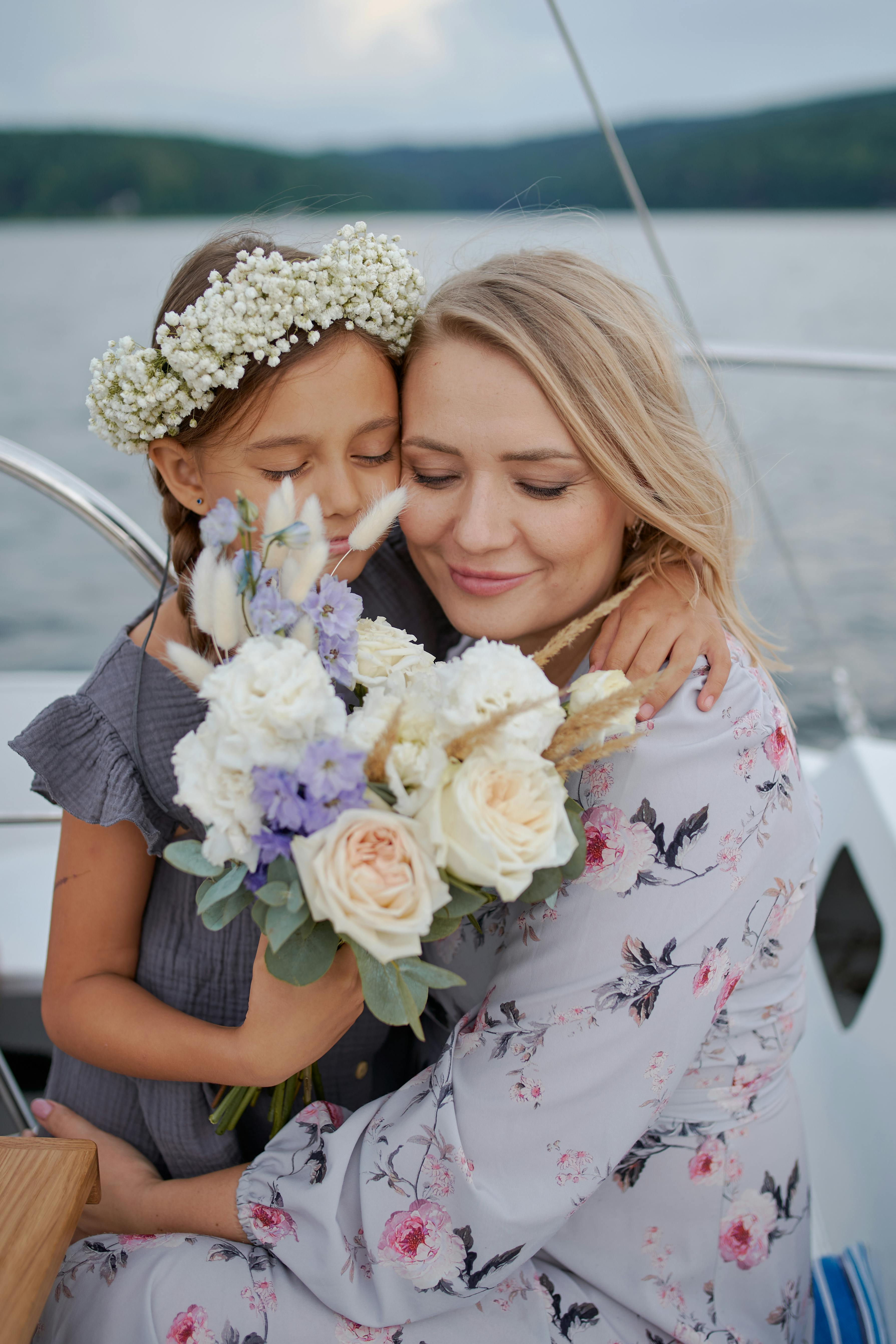 happy woman hugging daughter on boat