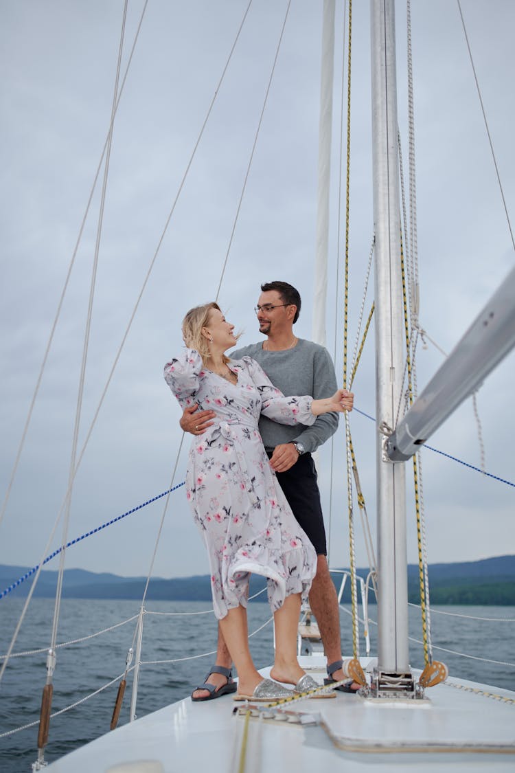 Happy Couple Embracing On Sailboat In Sea