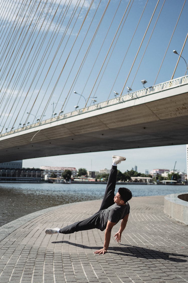 Unrecognizable Ethnic Man Dancing Break Dance On Embankment