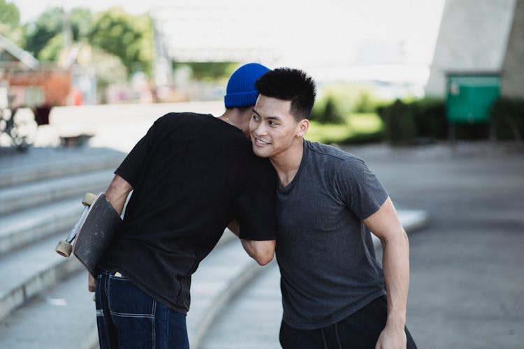 Positive Asian Men Greeting Each Other On Street