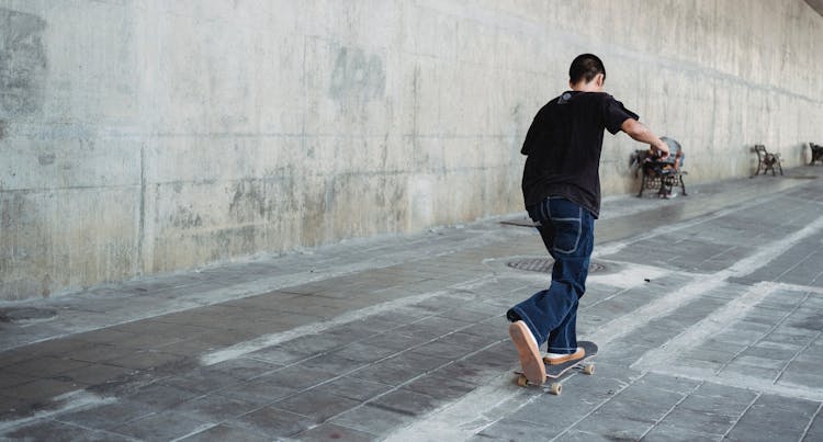 Teen Boy Riding Skateboard In City District