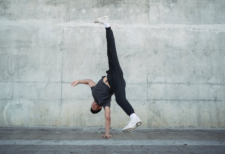 Young Man Dancing Hip Hop Style On Urban Landscape