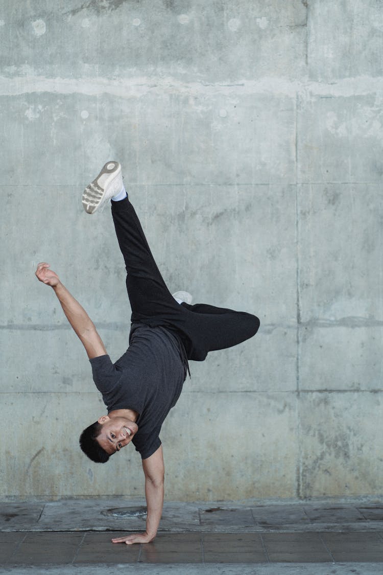 Young Man Practicing In Break Dance On Gray Street