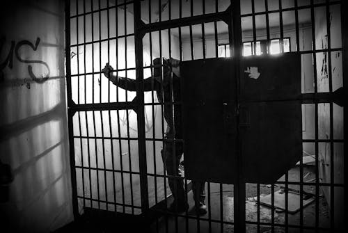 Grayscale Photo of a Prisoner Inside the Jail