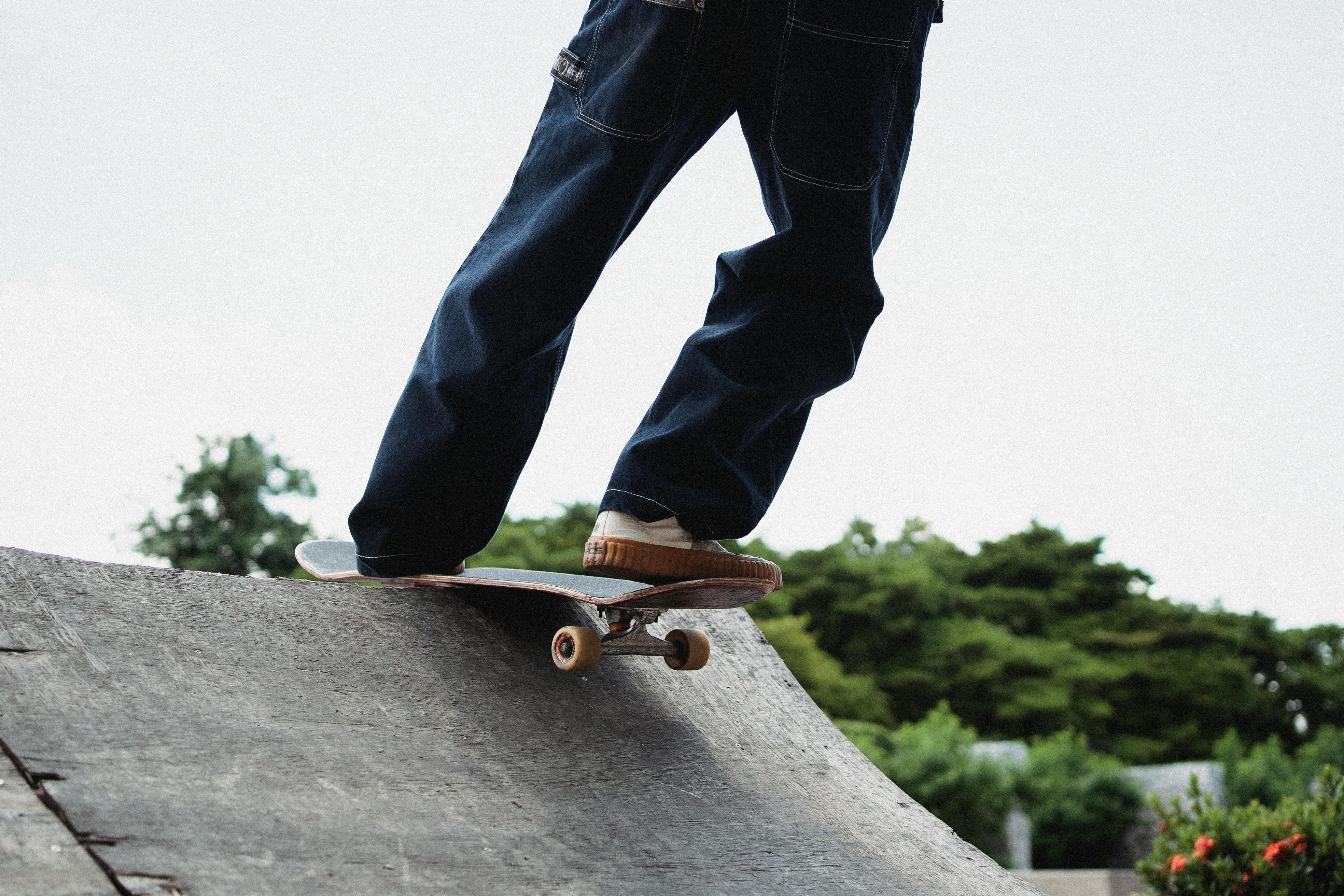 faceless sportsman skateboarding on ramp in skate park