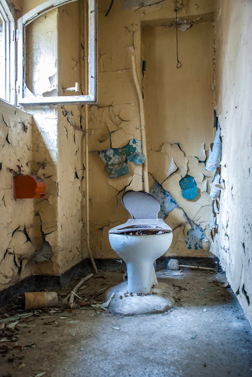 Free A Damaged Toilet Inside an Abandoned Building Stock Photo