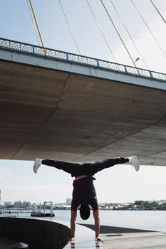 城市人行道上，一位无名运动员双手站立的背影