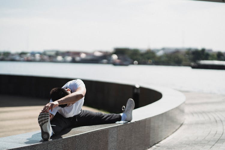 Young Man Stretching Body On Street