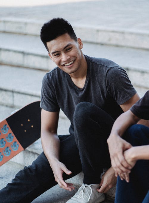 Man in Black Crew Neck T-shirt Sitting On Concrete Steps