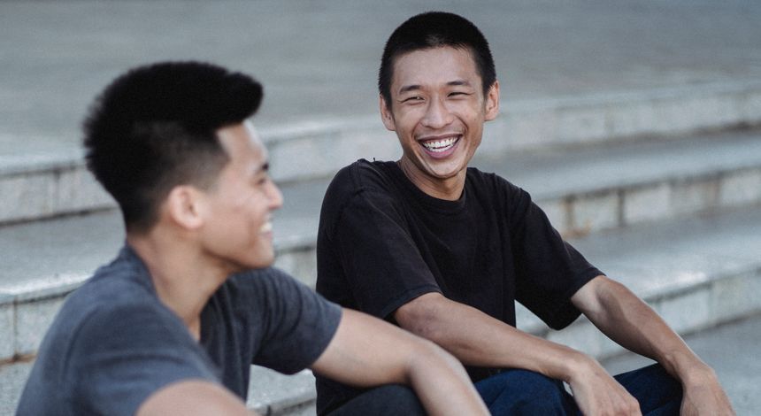 Two friends laughing together on a flight of steps &mdash; photo by Allan Mas on Pexels