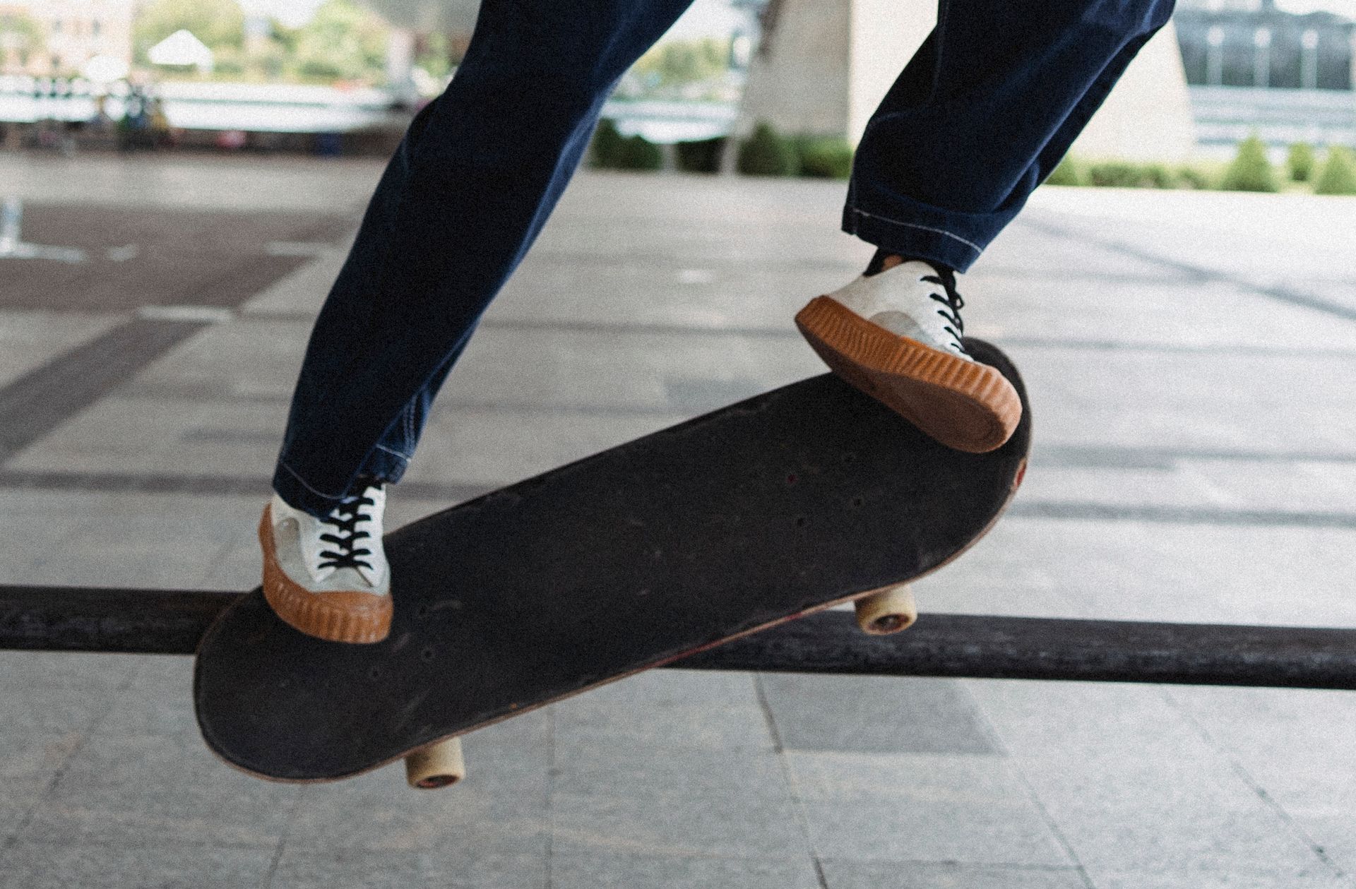 A skateboarder performing a trick with precision and style on a metal rail in an urban skate park.
