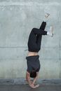 一名面目全非、穿着运动服的男运动员在街头跳霹雳舞时倒立的背影