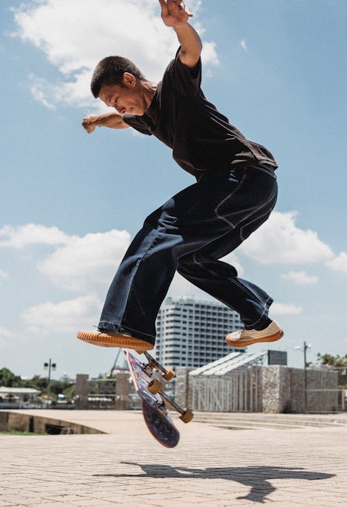 Young skater jumping on skateboard in park