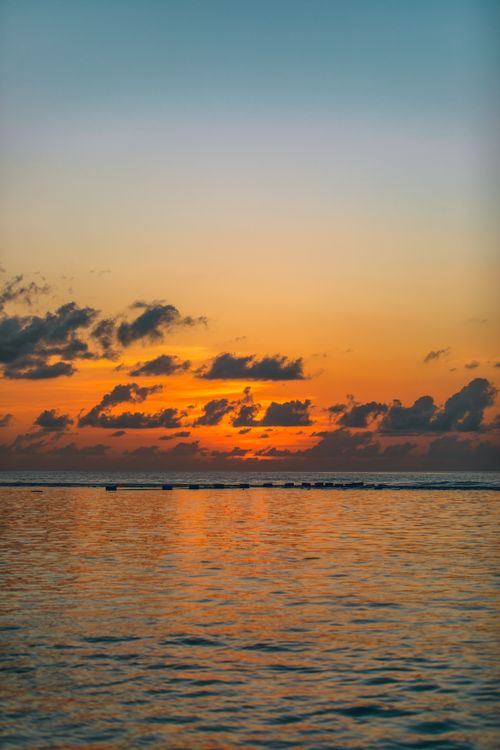 Free Amazing view of bright orange sunset sky reflecting in rippling calm sea in early evening Stock Photo