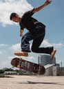 Young Asian man jumping with skateboard