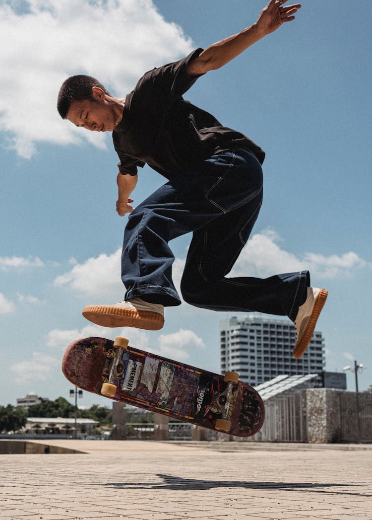 Young Asian Man Jumping With Skateboard