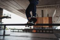 Unrecognizable skater doing grind trick on rail in skater training area