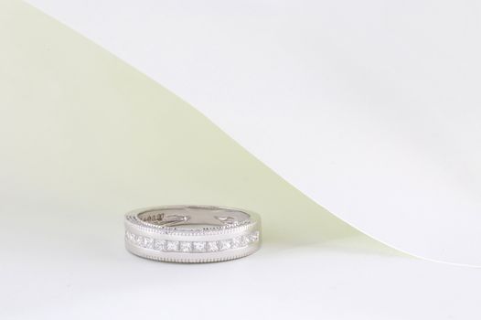 A luxurious diamond ring showcased elegantly on a white and minimal background.