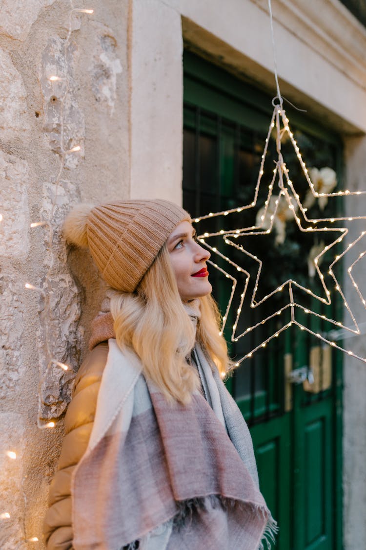 A Woman In Brown Knit Cap Standing Beside The Christmas Lights