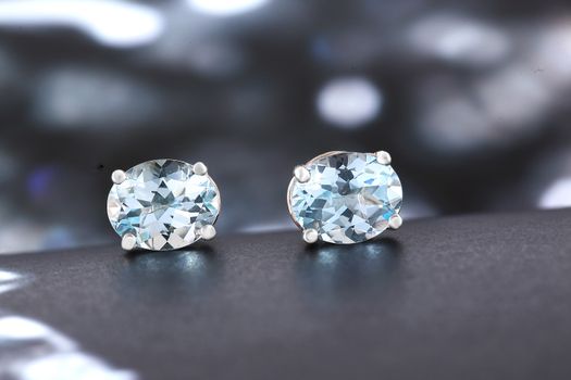 A stunning close-up of two aquamarine gemstone earrings, showcasing their intricate design and sparkling clarity.