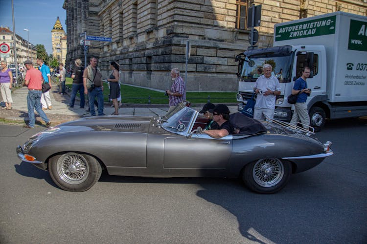 Man And Woman Riding A Vintage Car