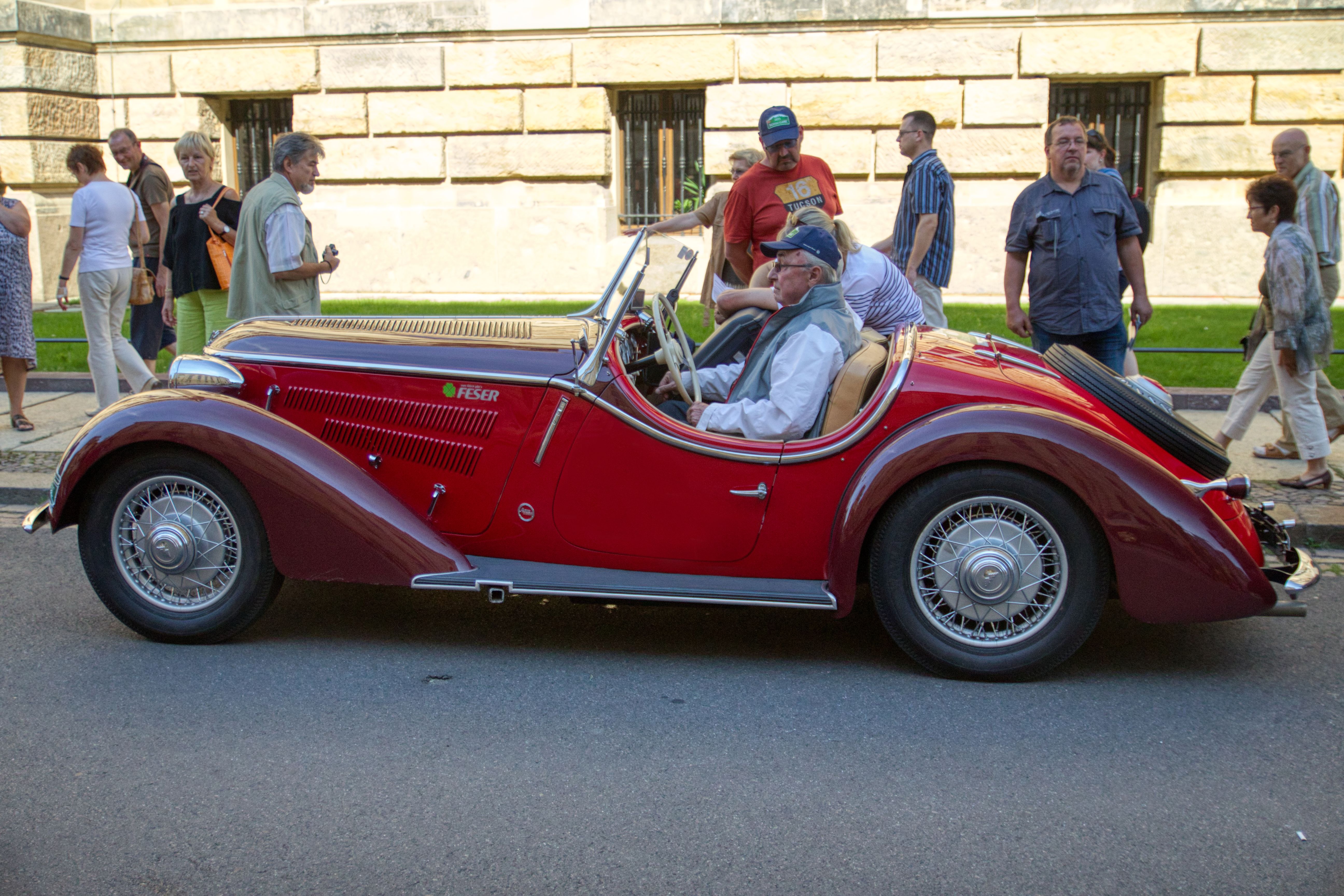 An Elderly Man Riding a Vintage Car · Free Stock Photo