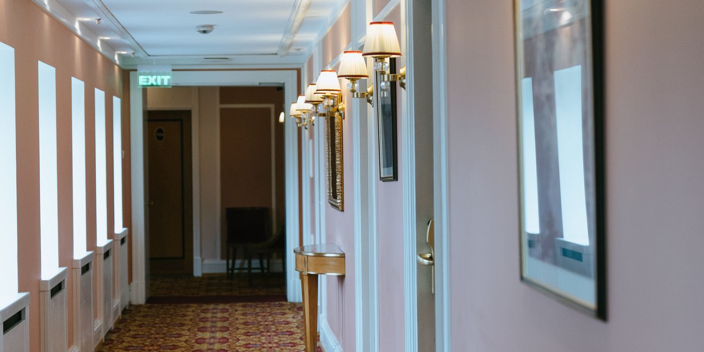 Hotel corridor with numbered guest room doors leading into the distance