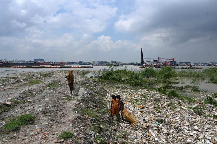 Women Collecting Garbage In Harbor