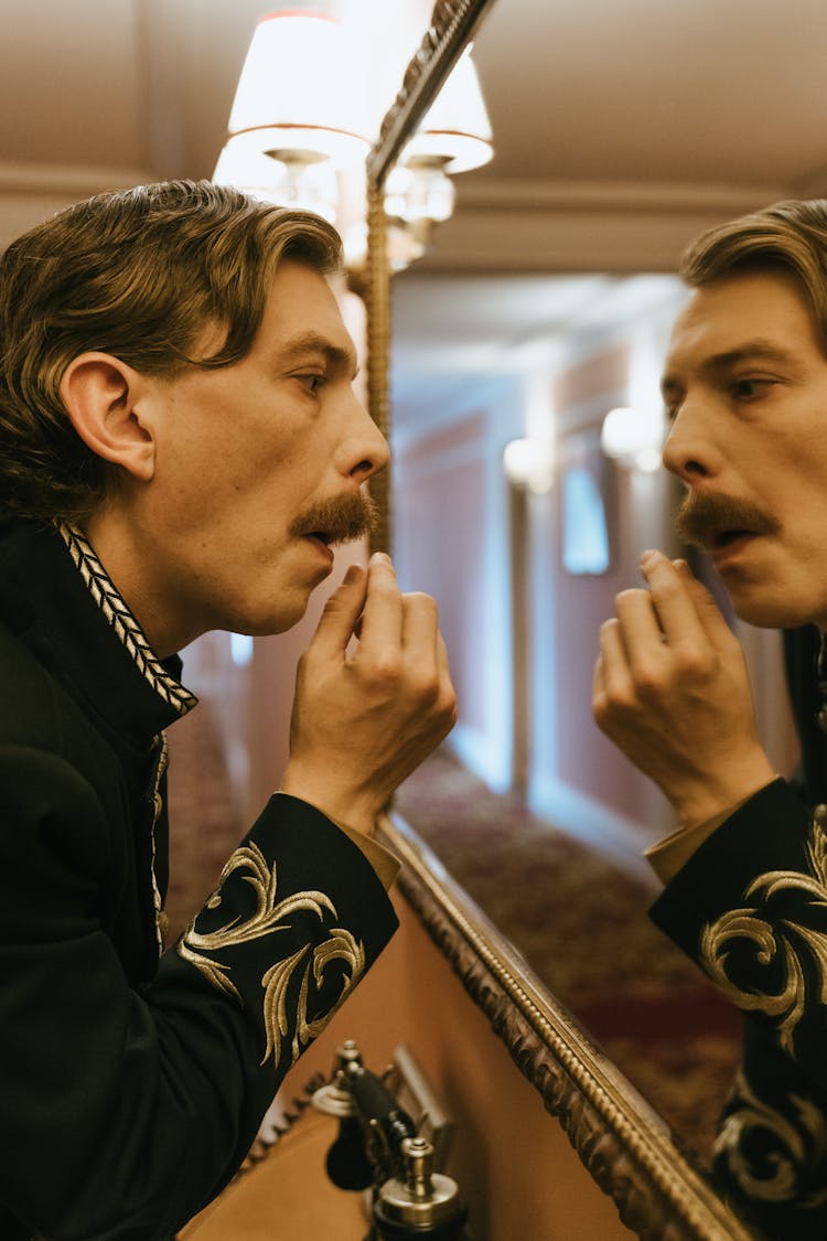 Man Looking At His Reflection In A Mirror 