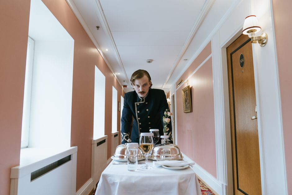 Serviço personalizado: Bellboy entrega room service em hotel de luxo, garantindo experiência exclusiva.