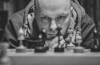 Man in Black and White Striped Hoodie Playing Chess