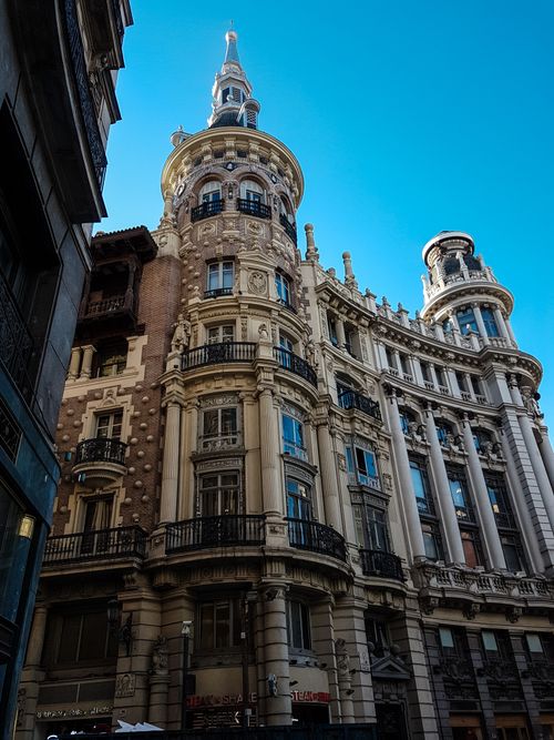 Free Captured architecture of the historic Meneses Building under a clear blue sky in Madrid, Spain. Stock Photo
