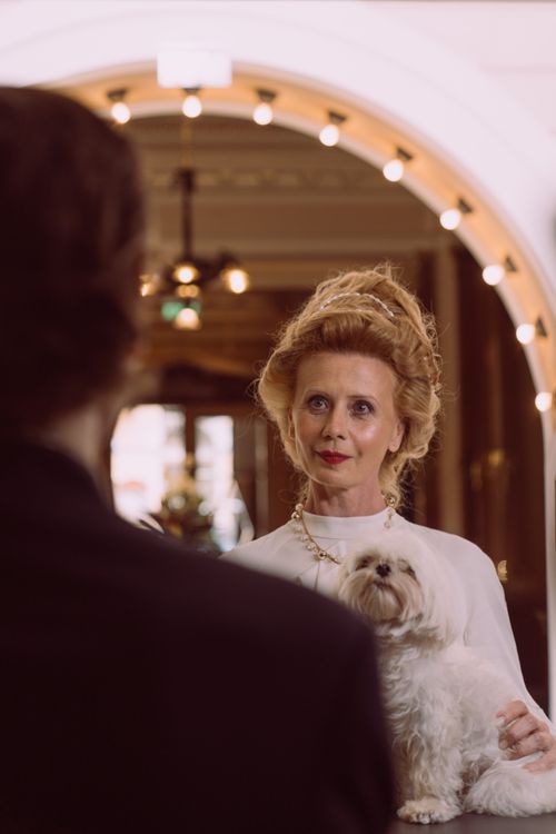 Free Sophisticated elderly woman with dog at elegant hotel reception. Stock Photo