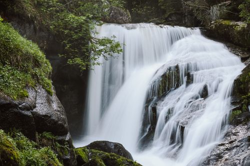 Free Fast powerful waterfall among heavy stones in forest with green trees in daytime in summer Stock Photo