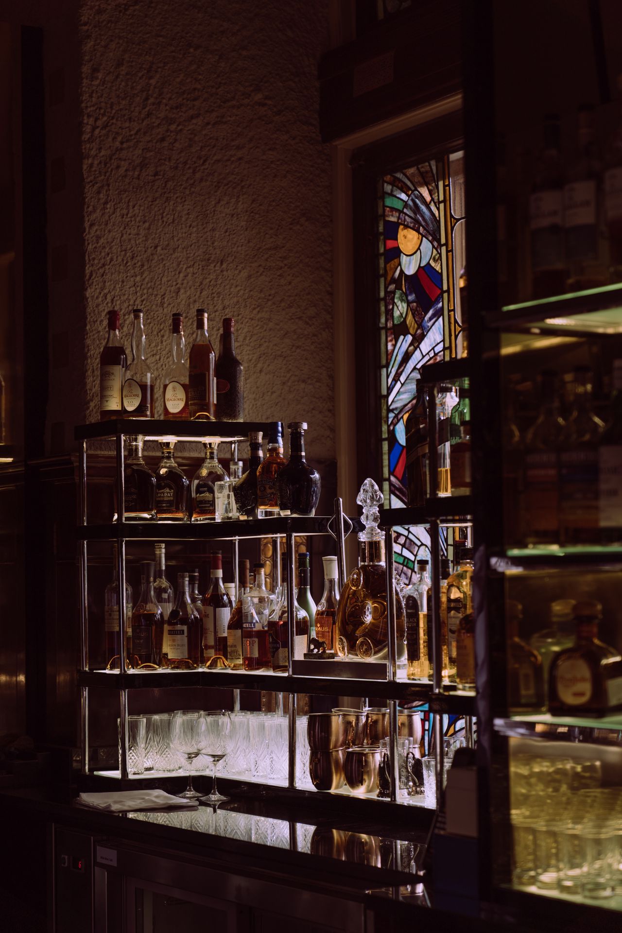 An atmospheric bar scene showcasing a variety of liquor bottles on display