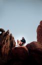 Woman in Black Crop Top and Black Shorts Sitting on Brown Rock Formation