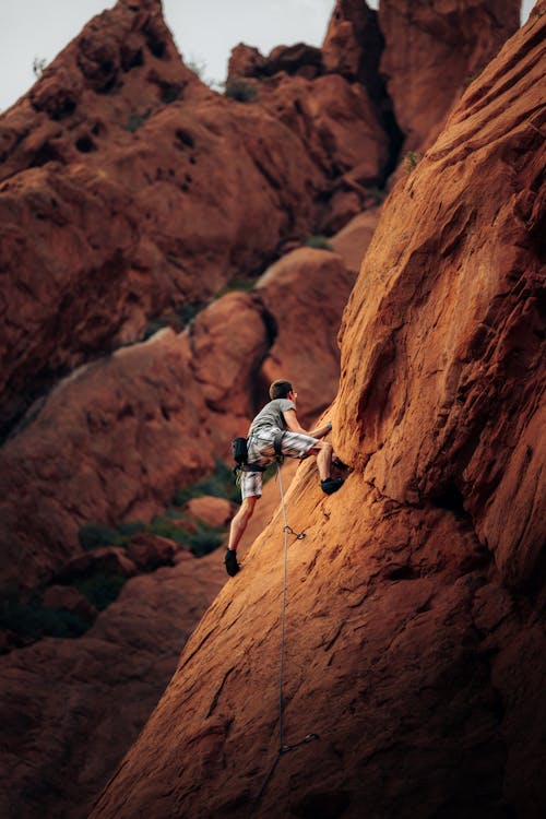 Free Man Rock Climbing on Mountain Side Stock Photo
