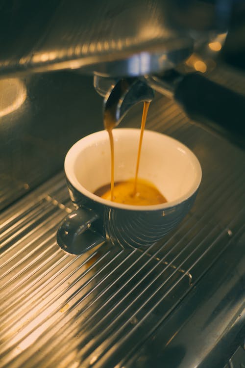 Free Coffee Machine Pouring Coffee on a Ceramic Cup Stock Photo