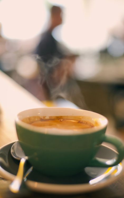 A steaming cup of coffee on a cafe table