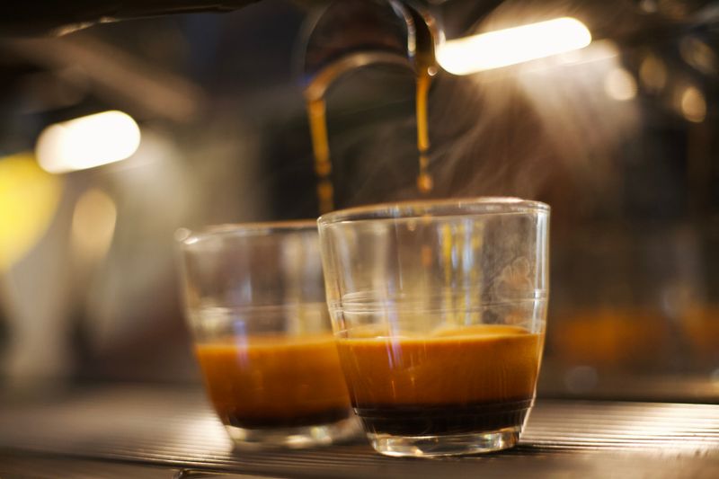 Two glasses filling under an espresso machine — photo by Inti Tupac Liberman on Pexels