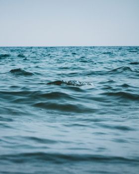 Calm ocean waves gently ripple across the sea surface, evoking peace and tranquility.