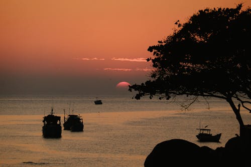 Silhouette of Ships on the Ocean during Sunset