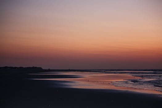 Tranquil sunset view over a serene Dutch beach, capturing the beauty of the horizon.