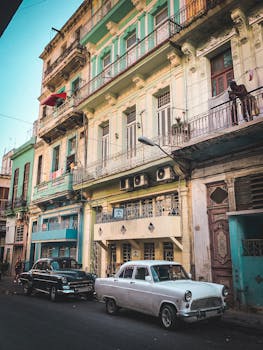 Colorful colonial architecture and vintage cars on a street in Havana, Cuba. Capturing Cuban culture.